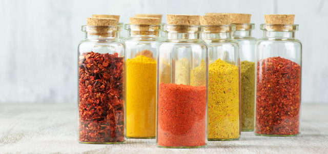 A set of colorful glass spice jars.