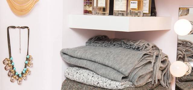 The interior view of a walk in closet with ample shelving for folded clothing and accessories.