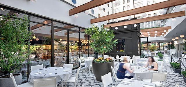 An outdoor restaurant in NYC with wooden beams.
