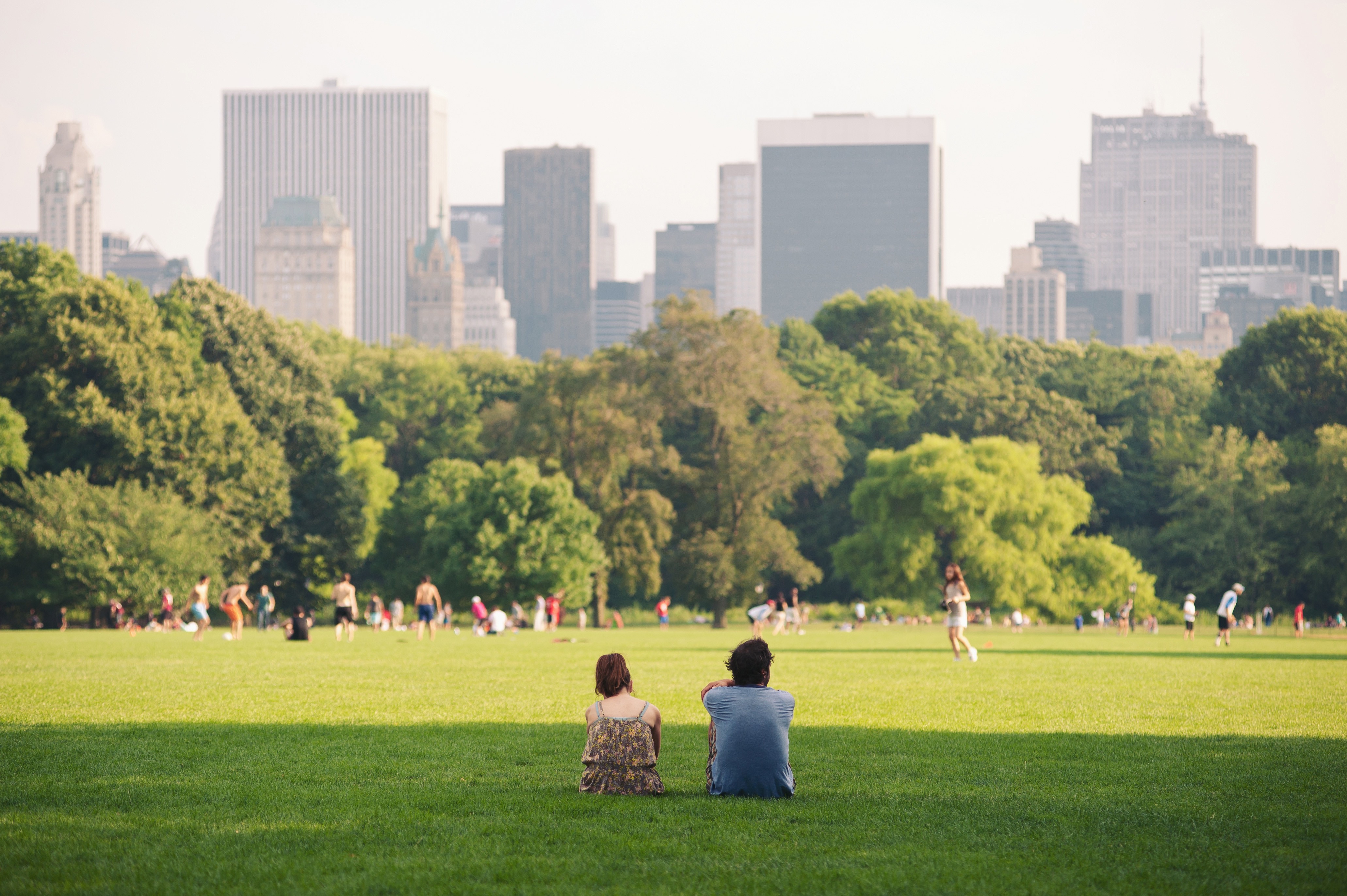 A couple sitting on the grass in central park