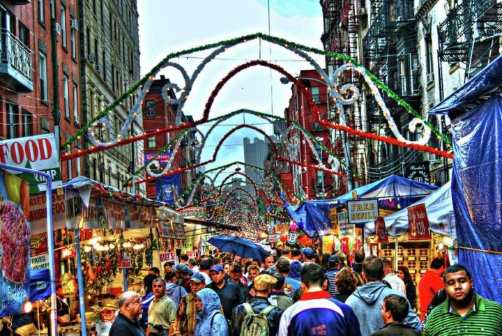 Streets of little italy filled with people and food vendor stands