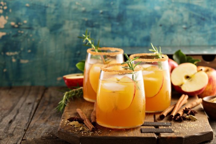 Apple cider on a tray with cinnamon sticks