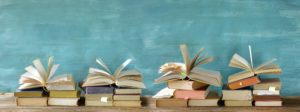 A stack of books opened on a blue background