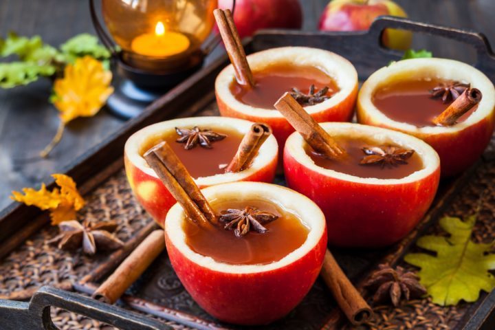 Apple cider in apple cups with cinnamon sticks