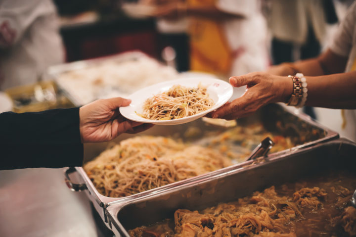 Individual volunteering at a food donation center handing out food