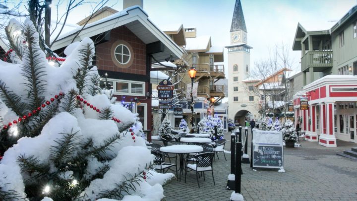 A snowy ski town with outdoor seating covered in snow
