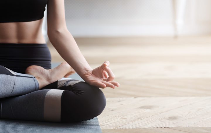 A woman doing yoga on a mat in her apartment