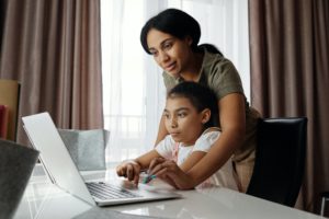 A mother and daughter on the computer together 