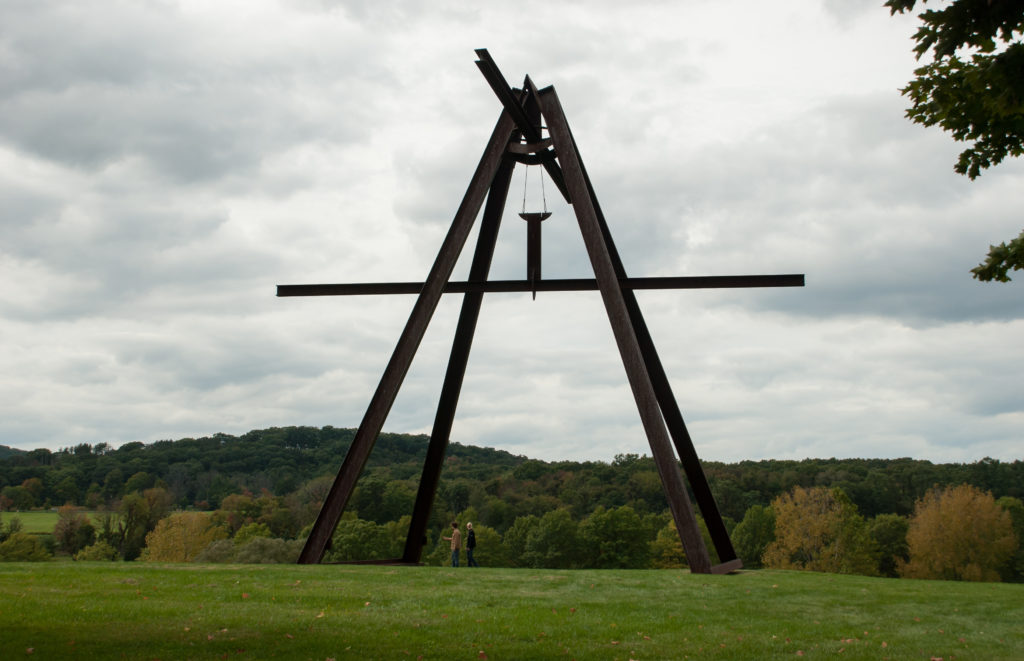 A tall outdoor sculpture in a field