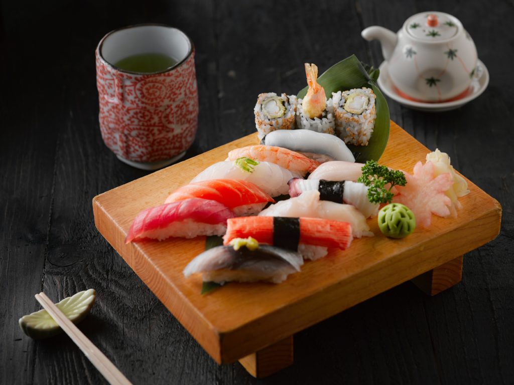 Omakase sushi on a plate with green tea on the side