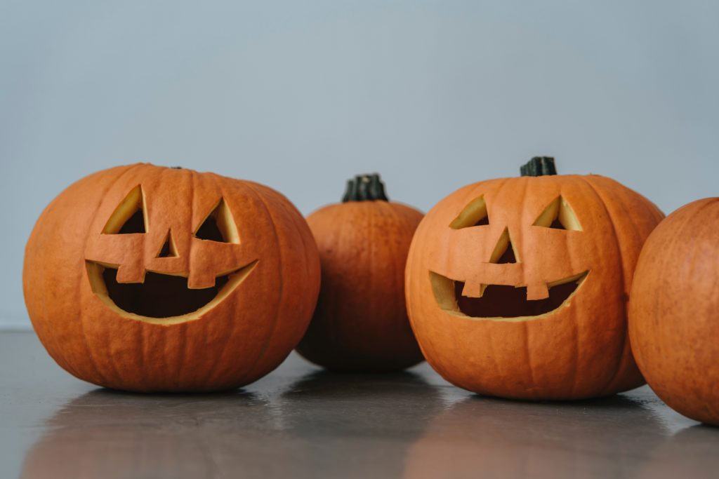 Carved happy face pumpkins on a grey floor and background