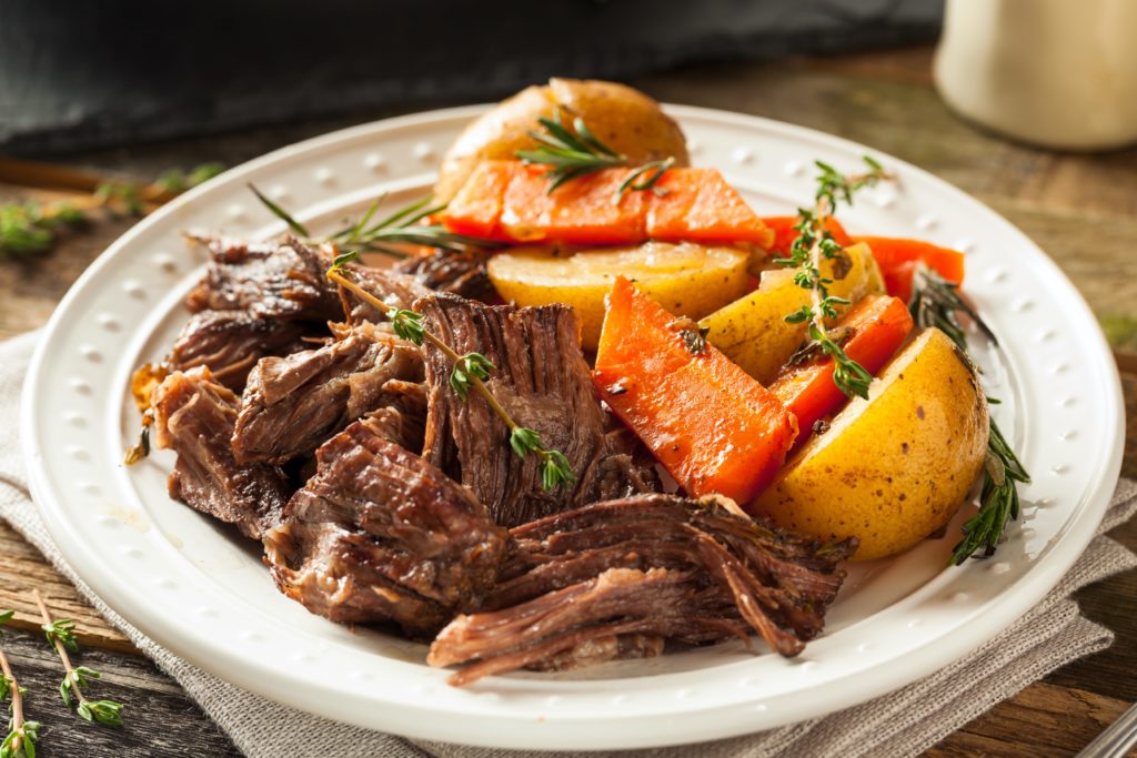 Pot roast and potatoes on a white plate