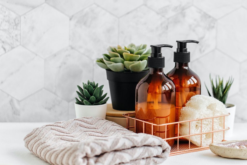 Zen bathroom scene with hand soap, hand towel, and succulent plants