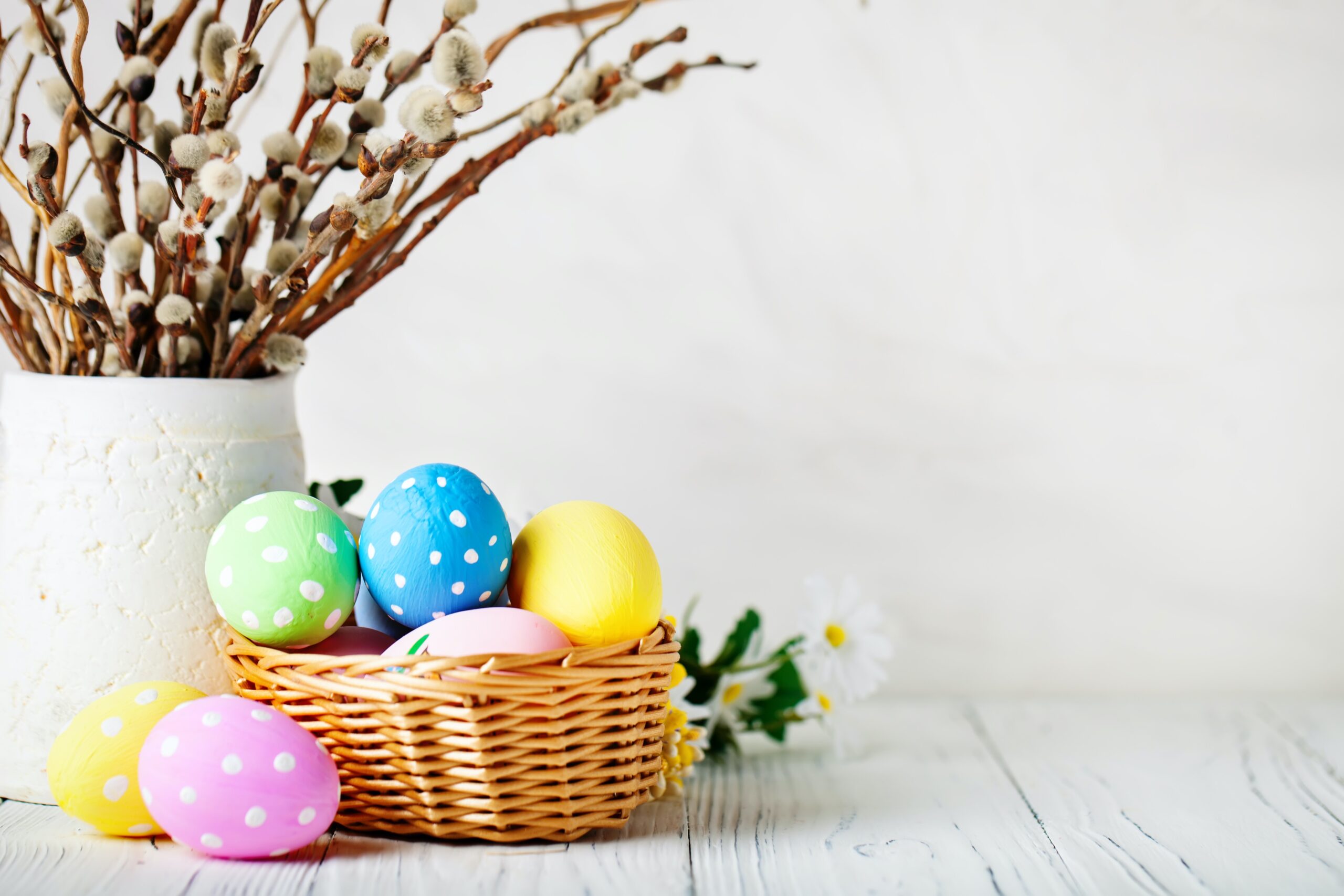 colorful Easter eggs in a basket with flowers