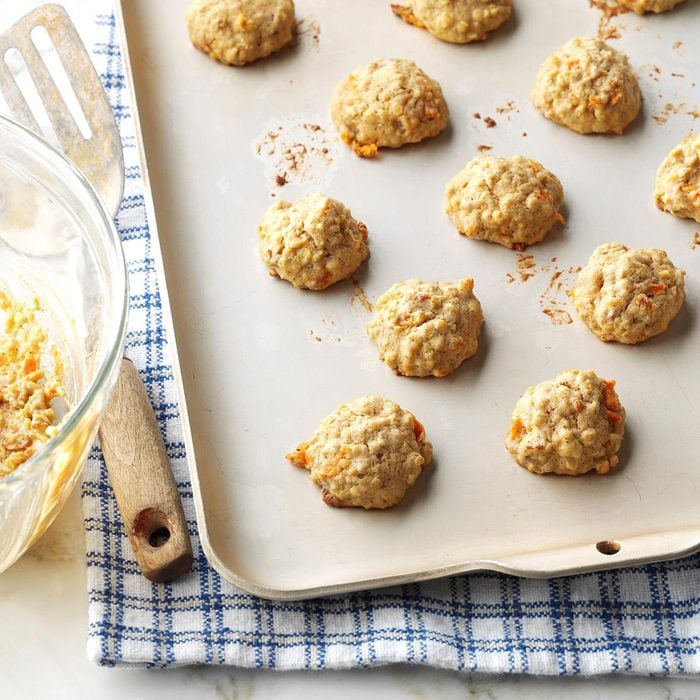 carrot cookies on backing sheet with blue and white checked mat under