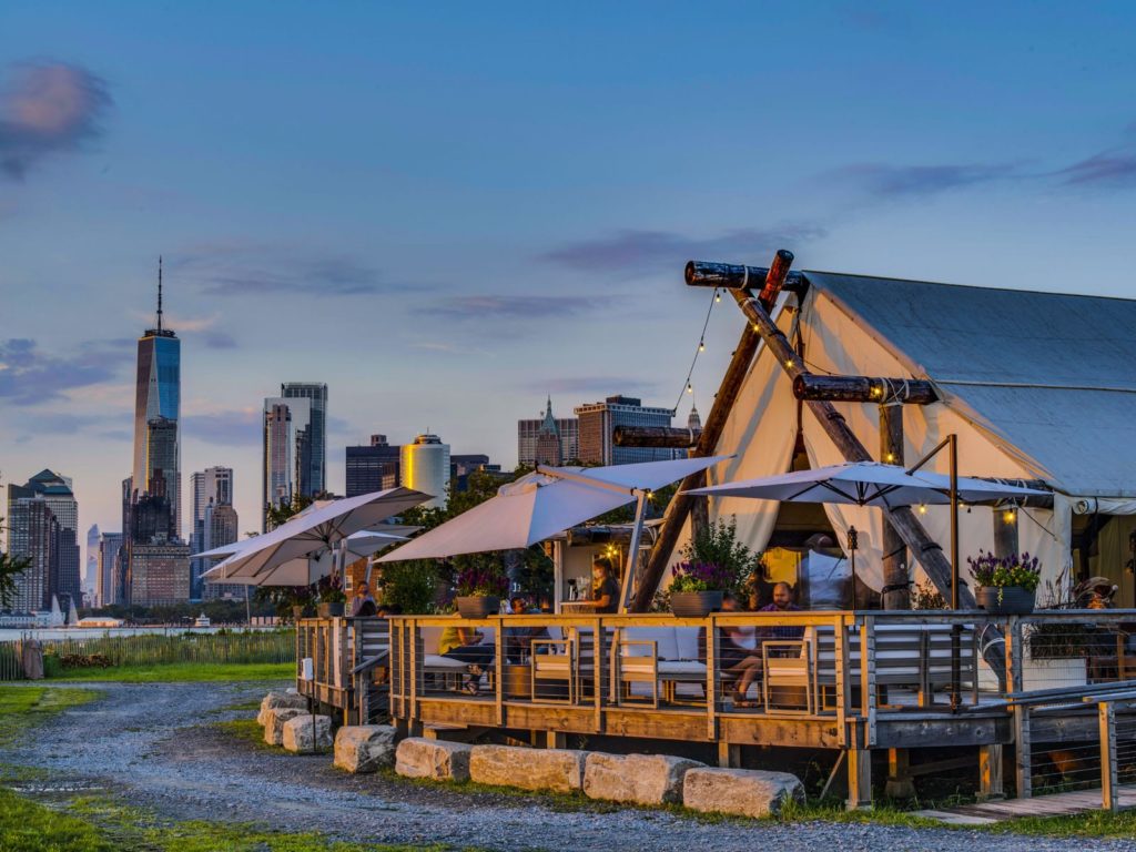 A luxurious glamping style restaurant with people eating on the terrace