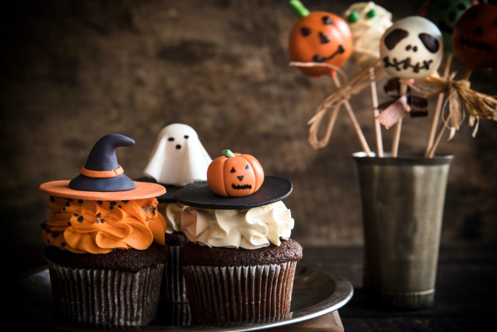 Funny cup cakes and cake pops as Halloween decoration on the wooden background,selective focus