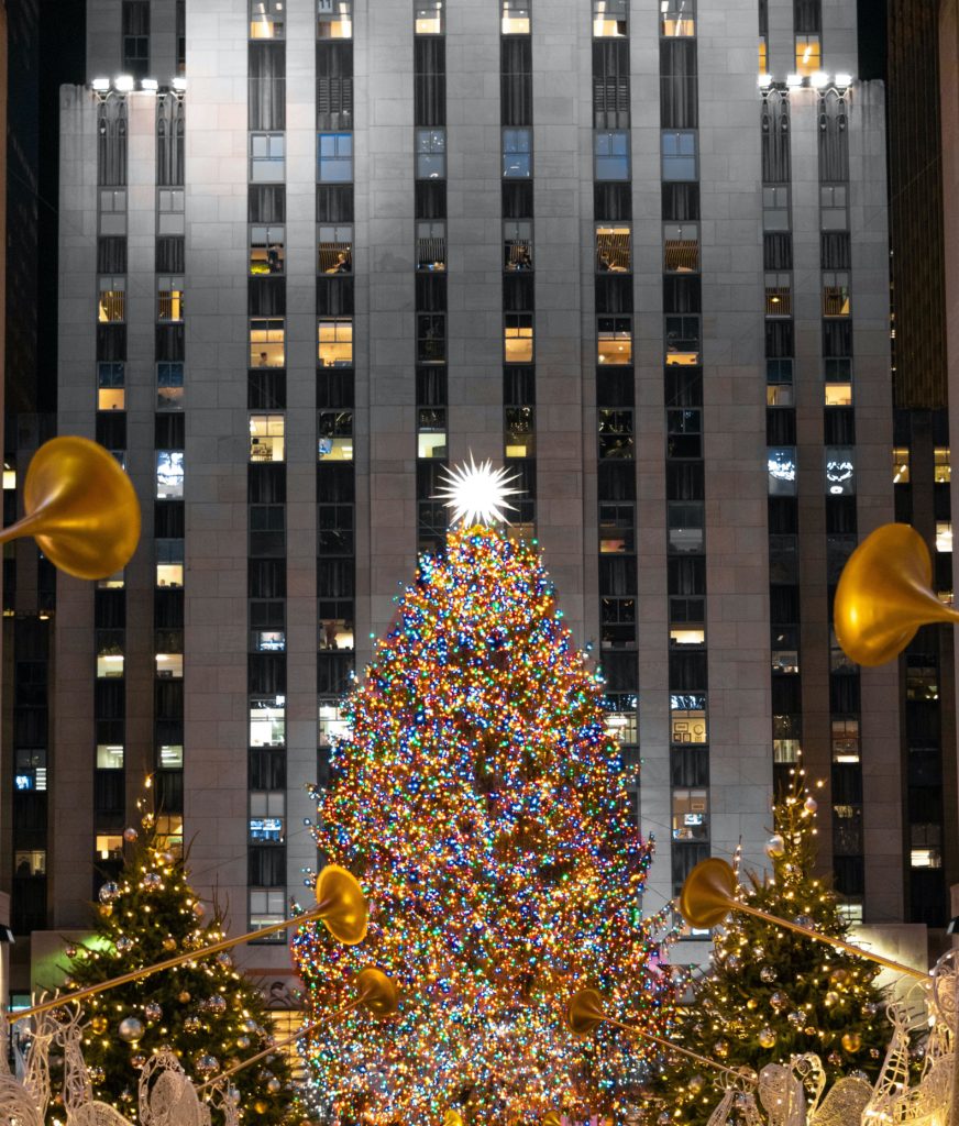 Rockefeller christmas tree with angel sculptures in front of it