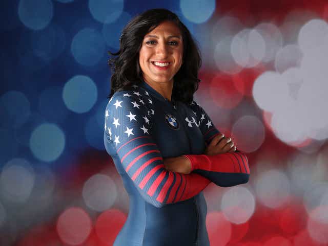 Elana in her USA olympic uniform standing in front of a red white and blue background 