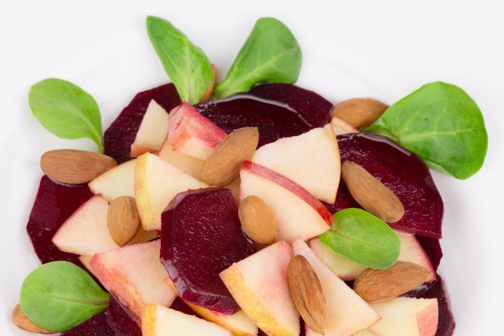 Beet salad with spinach and minced apple. Isolated on a white background.