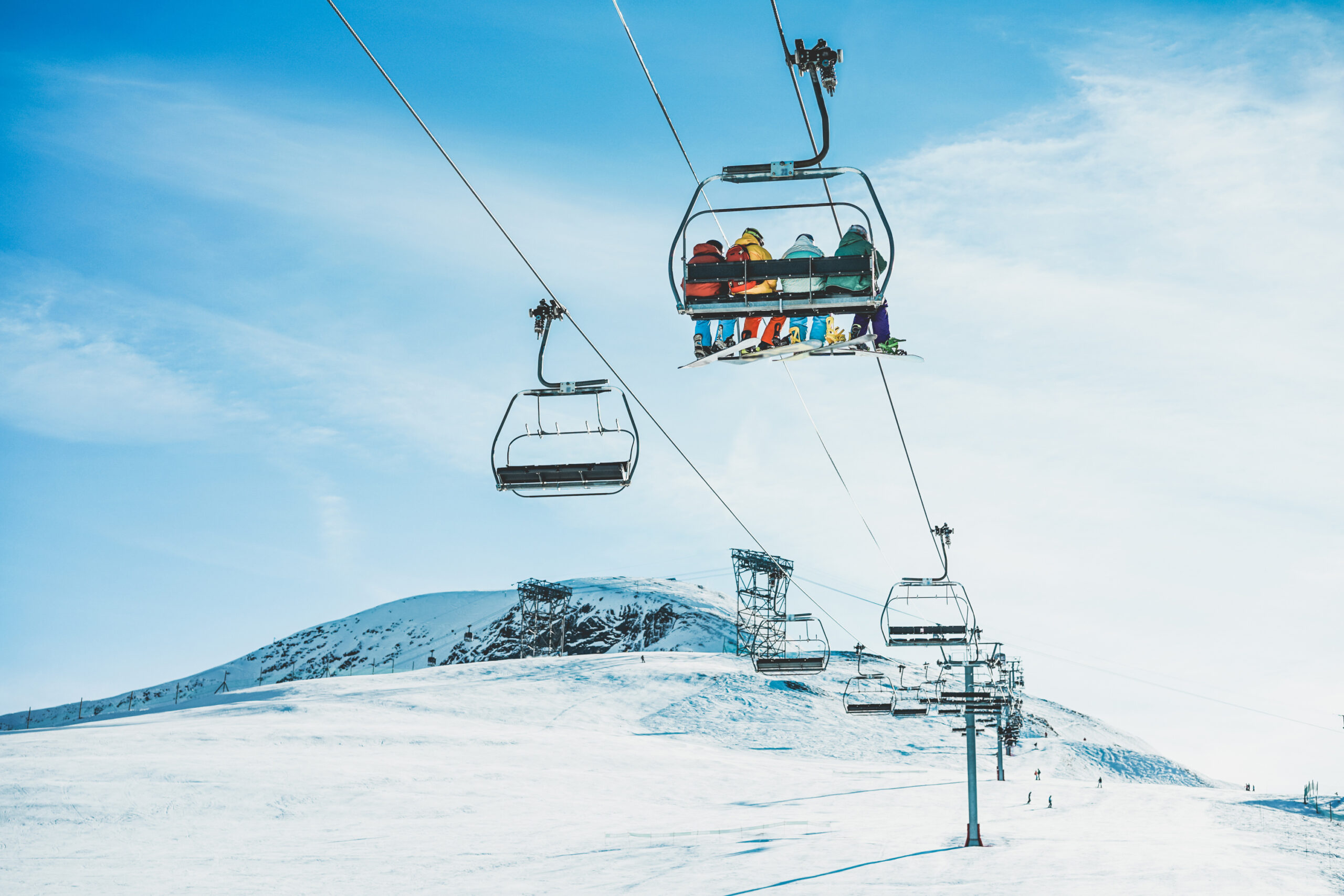 People on ski lift in winter ski resort - Holidays, snow gear renting, skiing, snowboarding and mountain landscape 