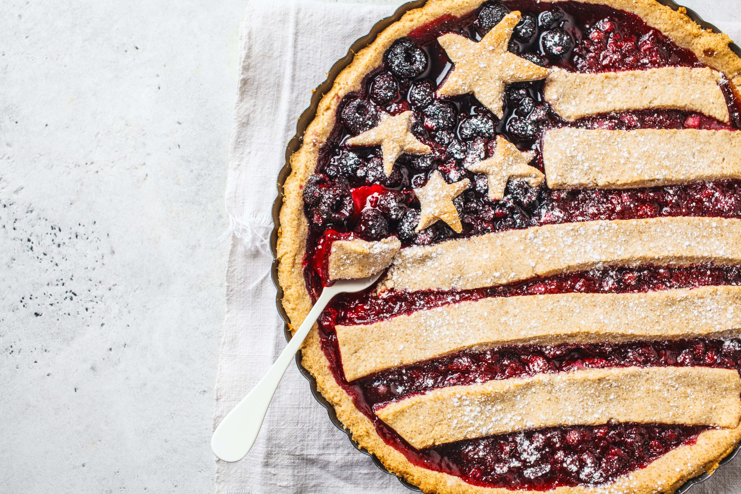 A mixed berry American flag pie with a fork in it