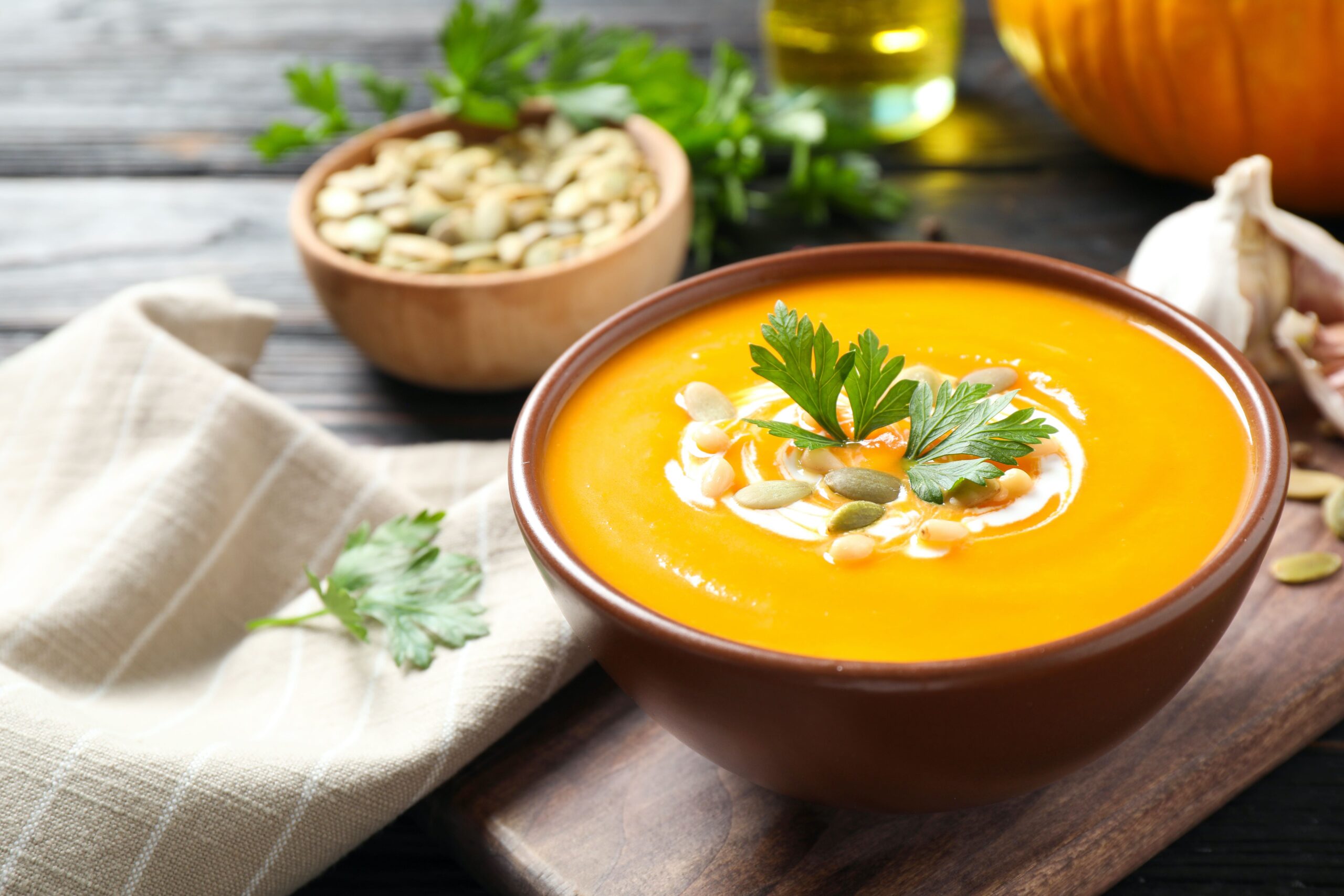 Delicious pumpkin soup in bowl on wooden table