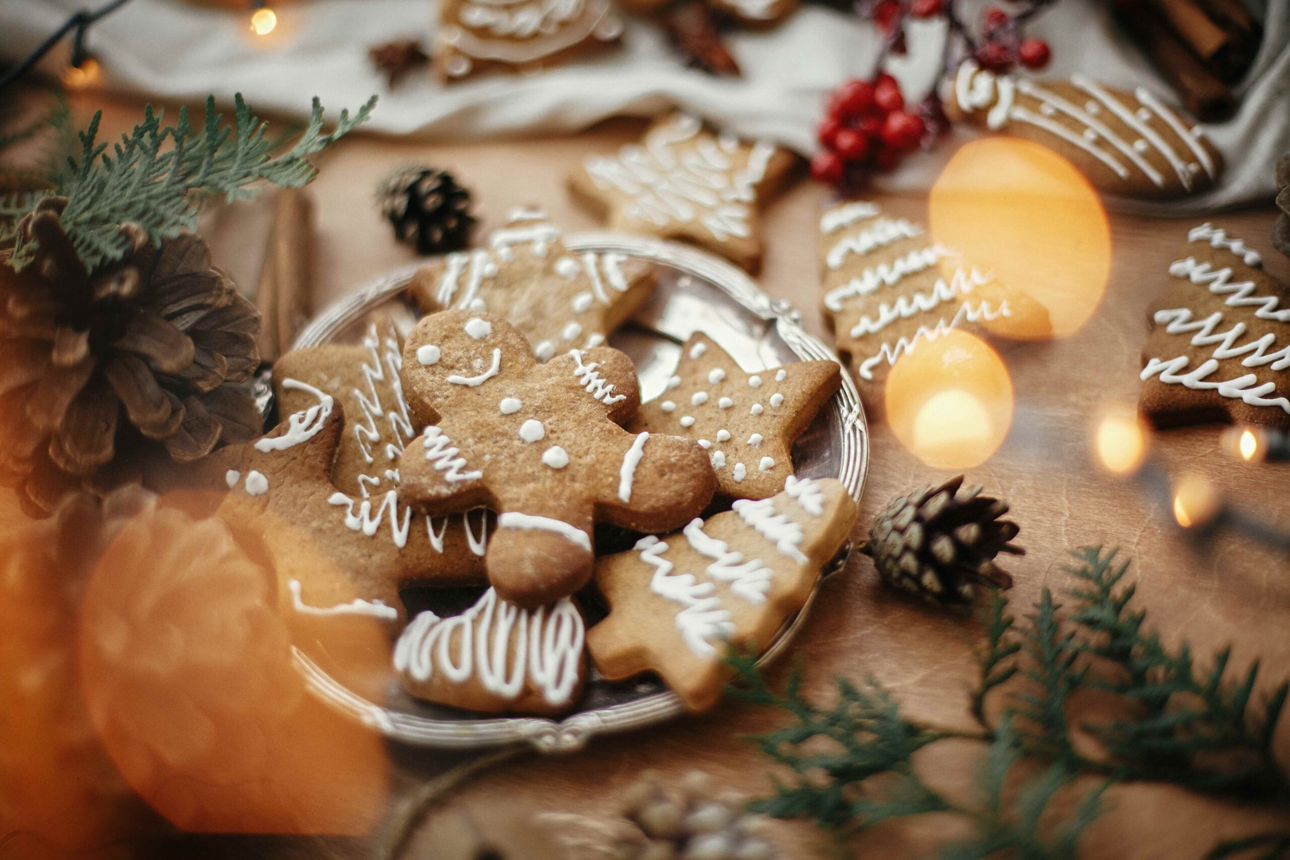 gingerbread cookies on a silver plate surrounded by pine cones, leaves and branches