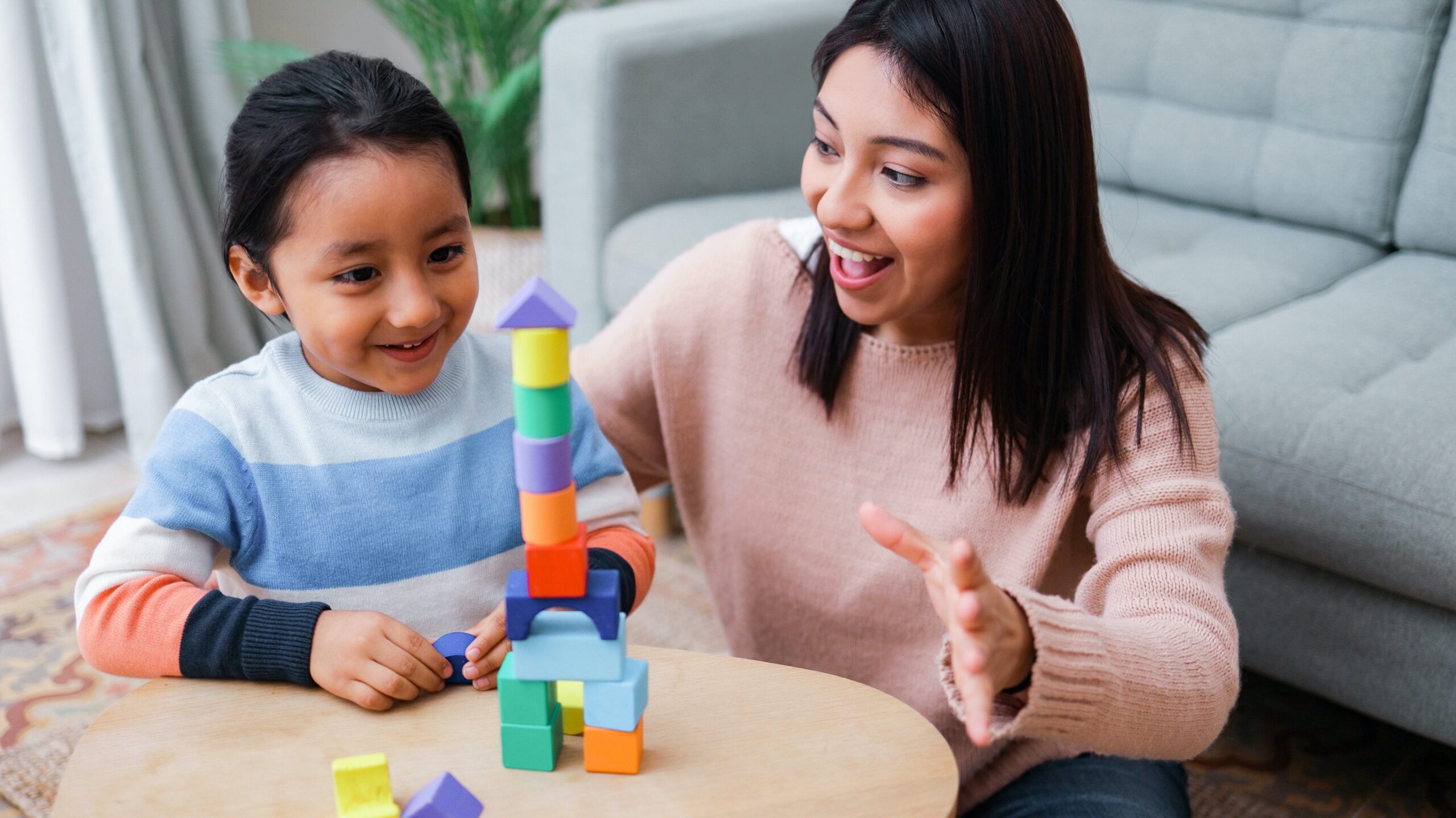 Mother plays blocks with daughter 