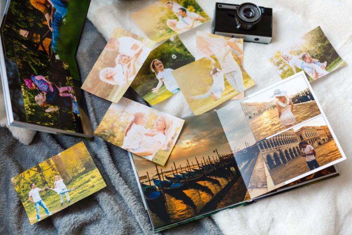 A camera, photoalbum, and photos laid out on blankets
