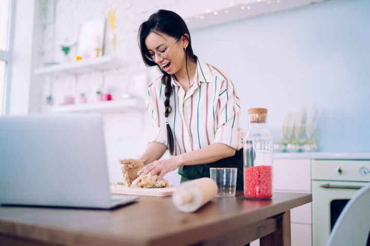 A woman taking an online cooking class while cooking