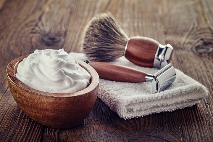 Men's Shaving accessories on wooden background including a razor, brush, and shaving cream