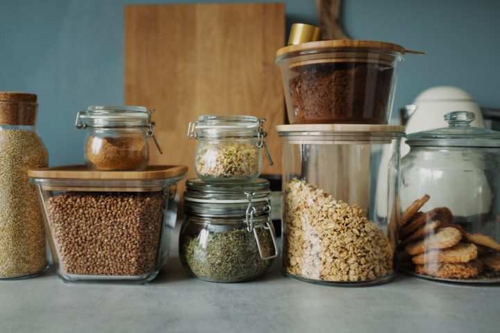 Baking ingredients displayed in glass jars on a kitchen counter
