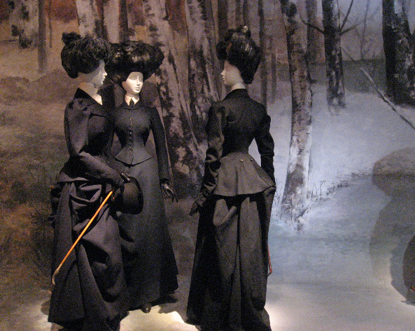 Fashion exhibition featuring mankins in black Victorian dresses and upswept hairdos
