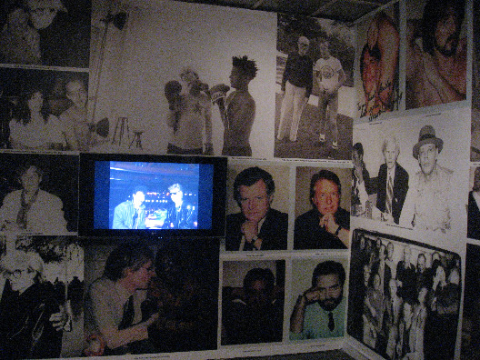 Andy Warhol art prints surrounding a flat screen video of the artist