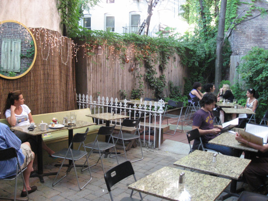 Bee Desserts and Cafe NYC outdoor patio is relaxing with rustic tables and chairs