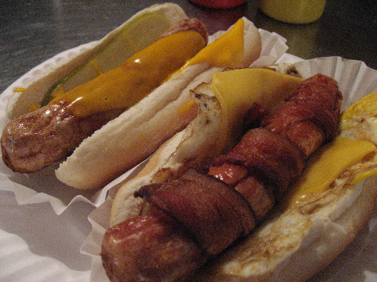 Best hot dogs in NYC bacon wrapped dog with cheese and cheesy pickle dog both on buns.