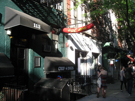 Crifs dogs NYC at ground level in the east village green building with black awning