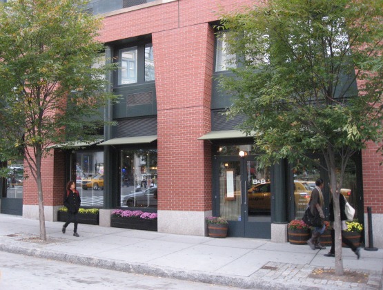 Exterios shot of Burger & Barrel in NYC - a brick building with dark green trim windows and two small trees in the front