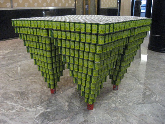 Green cans stacked to form upside down pyramids - architectural feat at the Canstruction NYC exhibition