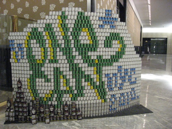 From the Canstruction 2010 show a stack of white cans interpresed with green, yellow, and blue nes to spell out one can nyc 2010