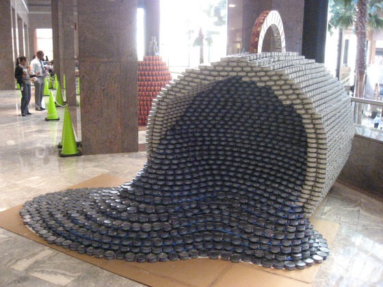 White cans stacked to make a giant coffee mug, knocked over with blue cans representing the coffee at Canstruction in New York