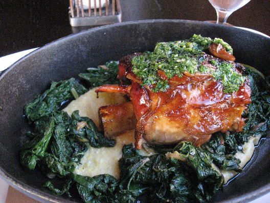Braised pork shank searved in a iron skillet over polenta and bitter swiss chard at the Colicchio and Sons NYC restaurant