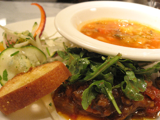 Chef Mario Batali dish of minestrone soup, eggplan caponata with arugala on top, fingerling potatoes, and garlicky bread