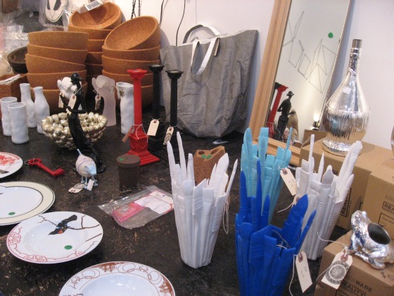 Plastic molded cups in the shape of paint brushes, plates and bowls on a table at the Black Market