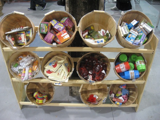 A wooden shelf with wood baskets full of small stocking stuffer gifts at the holiday pop Blue Ribbon General Store