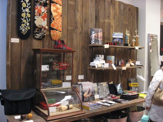A dark wood wall adorded with painted skateboards, books, trophies, and other fun holiday shopping gifts
