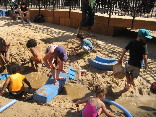 Kids dig in the sand to create tunnels and water channels at NYC's Imagination Playground