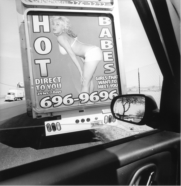 Image of a young women with the text hot babes framed by the side window photographer Lee Friedlander