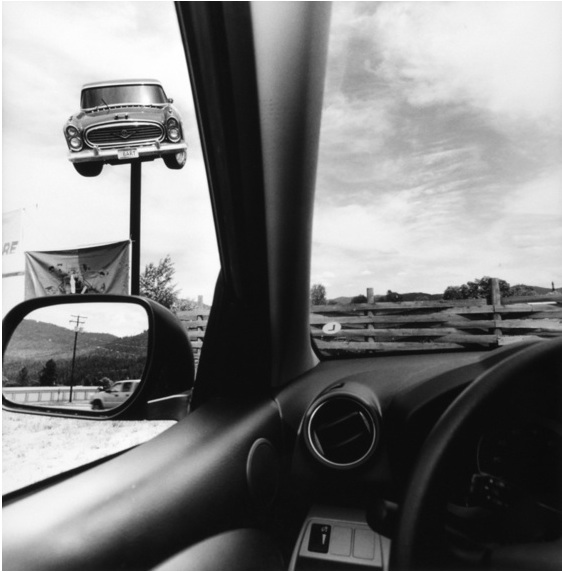 Lee Friendlander photographs at the Whitney museum use the inside of a car to frame signs like this 1950's car 